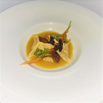 Obrázek Ravioli plněné kuřecími játry, žampióny a jablky, podávané na šafránovo-zeleninové omáčce.